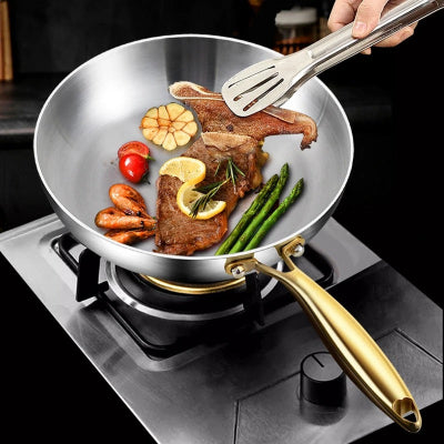 poele en inox cuisant des legumes et de la viande en simultanée